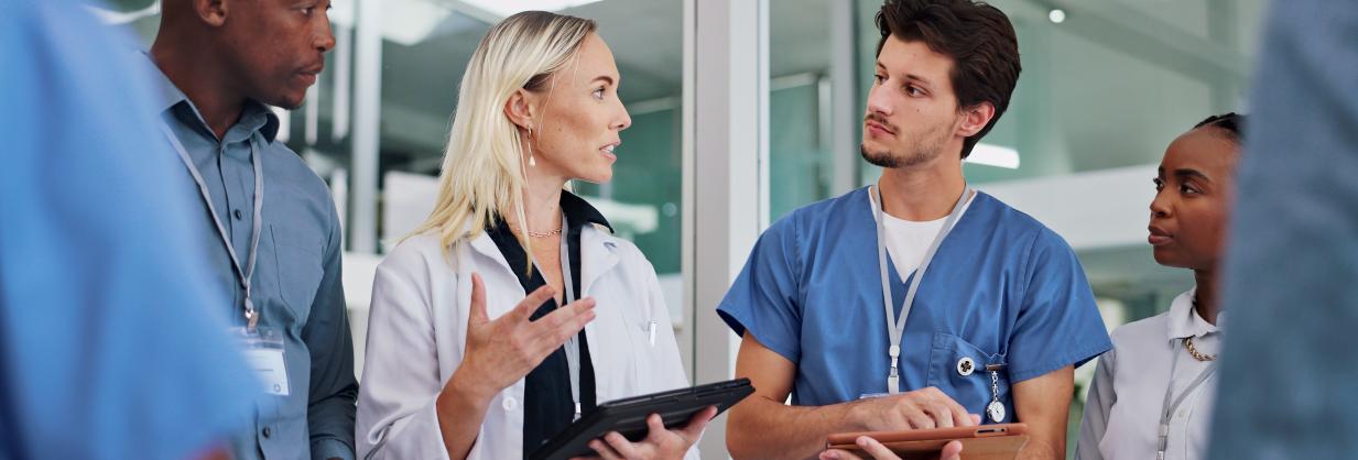 Healthcare professionals in scrubs having a conversation.