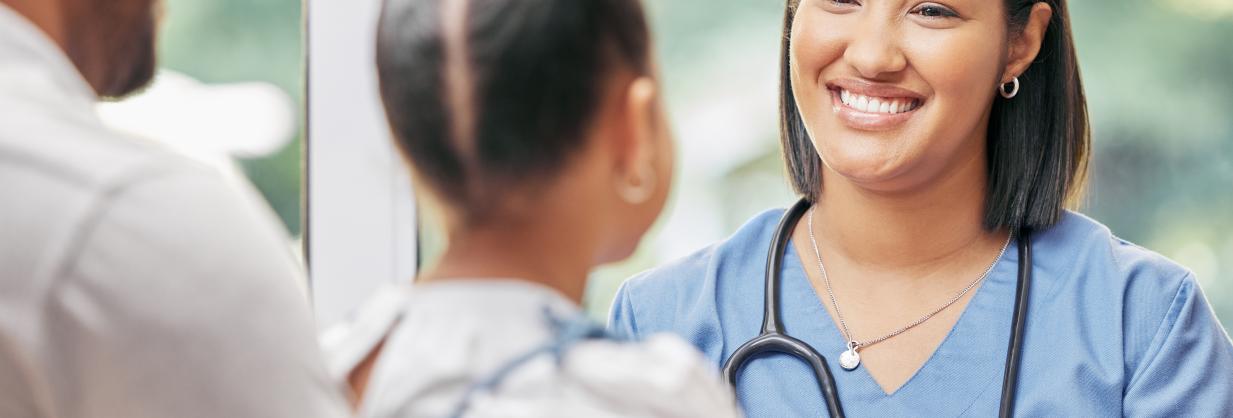 Registered nurse smiling at a young girl and her father.