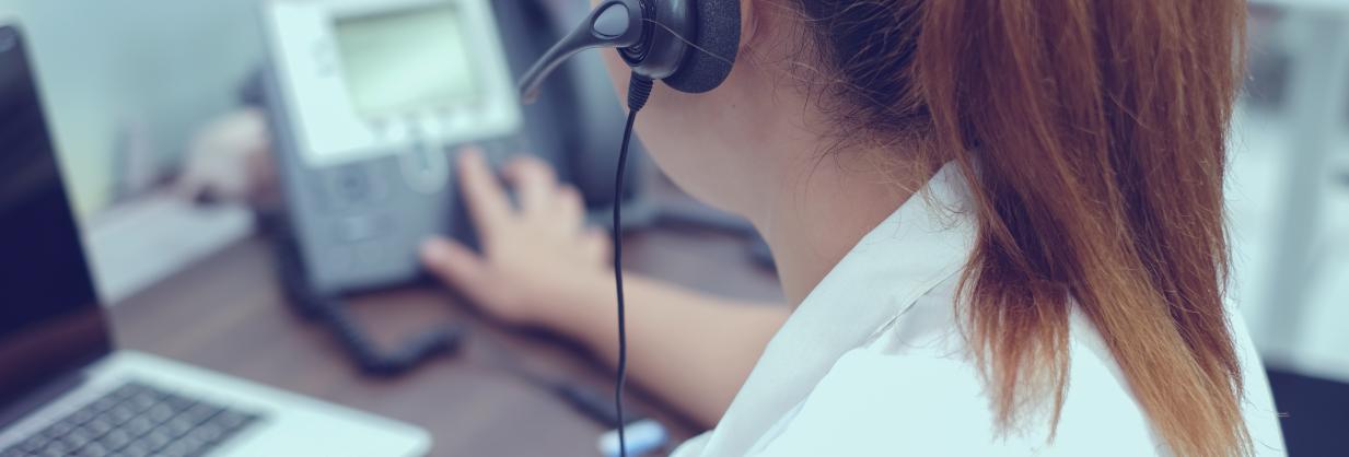 Woman answering a phone at her desk.