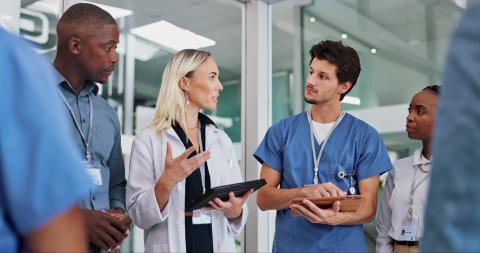 Healthcare professionals in scrubs having a conversation.