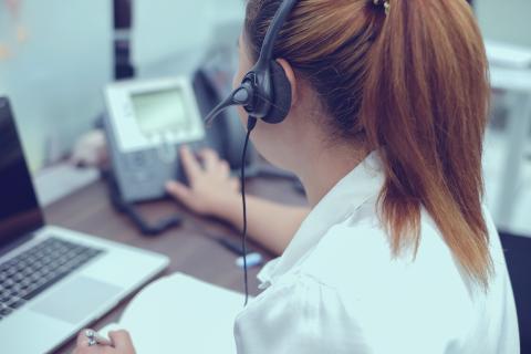 Woman answering a phone at her desk.